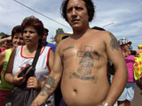 Fotografia Gaucho Antonio Gil, Cada persona tiene su forma de acercarse al gaucho Gil. Hay quien se acerca vestido de gaucho, quien se hace un tatuaje con su imagen, o quienes visten con alguna prenda de color roja y quien carga una cruz con su imagen.